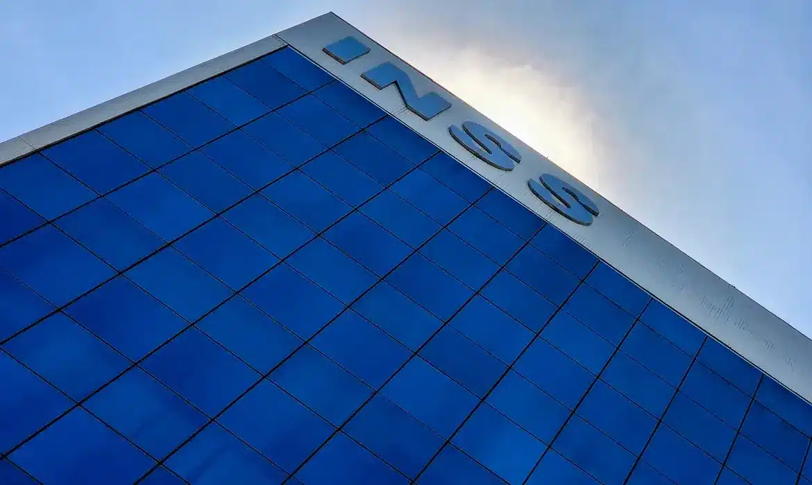 Fachada moderna do prédio do INSS destacando retorno do atendimento presencial após suspensão temporária