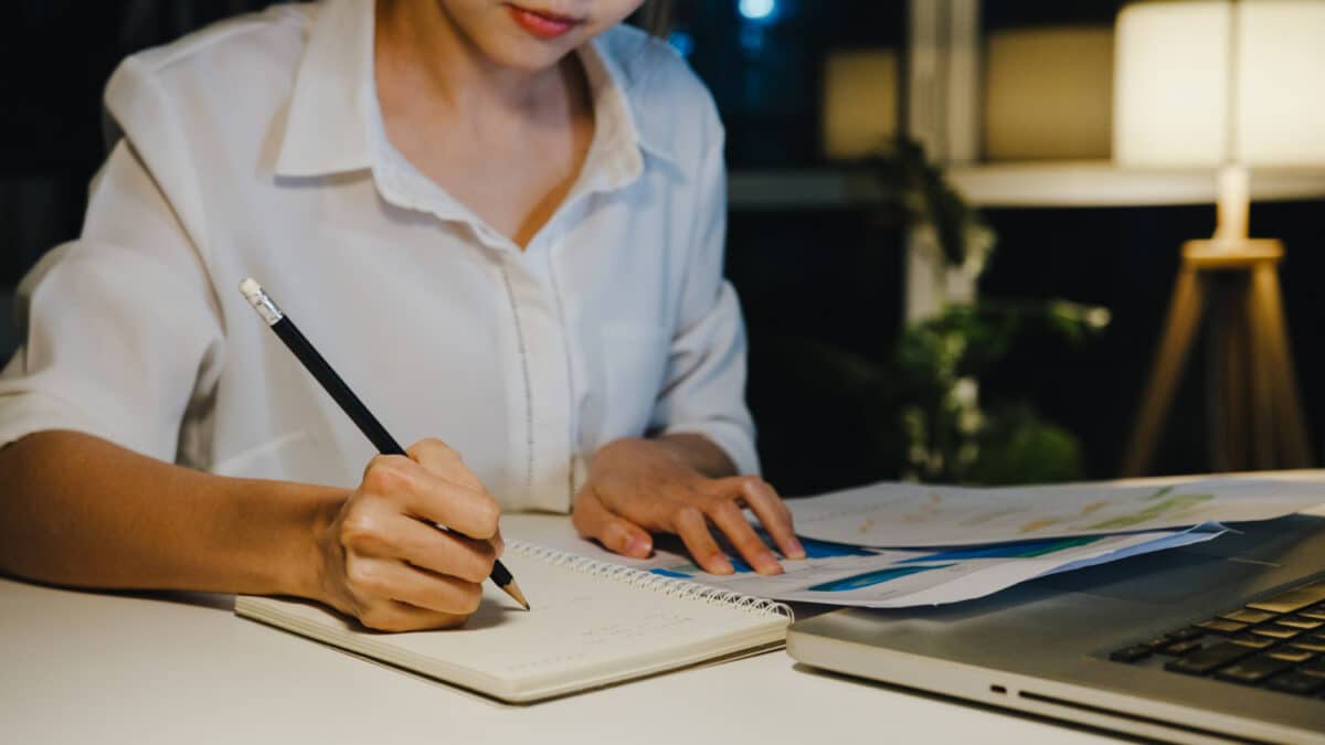 5 possíveis temas redação Enem 2026 - jovem estudando à noite com caderno lápis e notebook