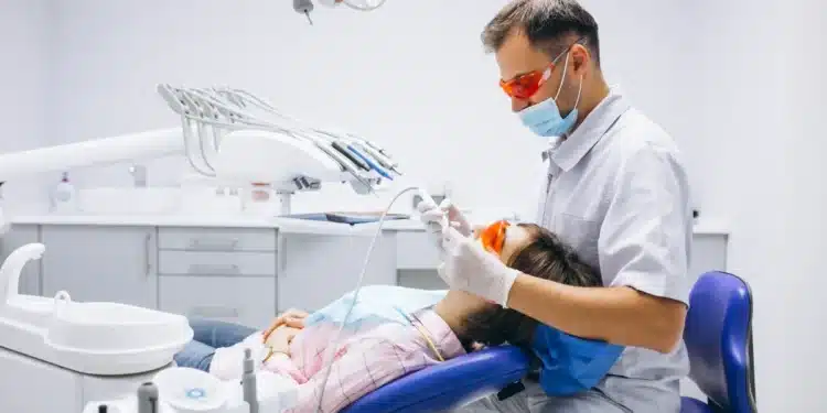 Jovem em consulta odontológica representando o atendimento dentário gratuito em 156 municípios
