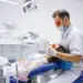 Jovem em consulta odontológica representando o atendimento dentário gratuito em 156 municípios