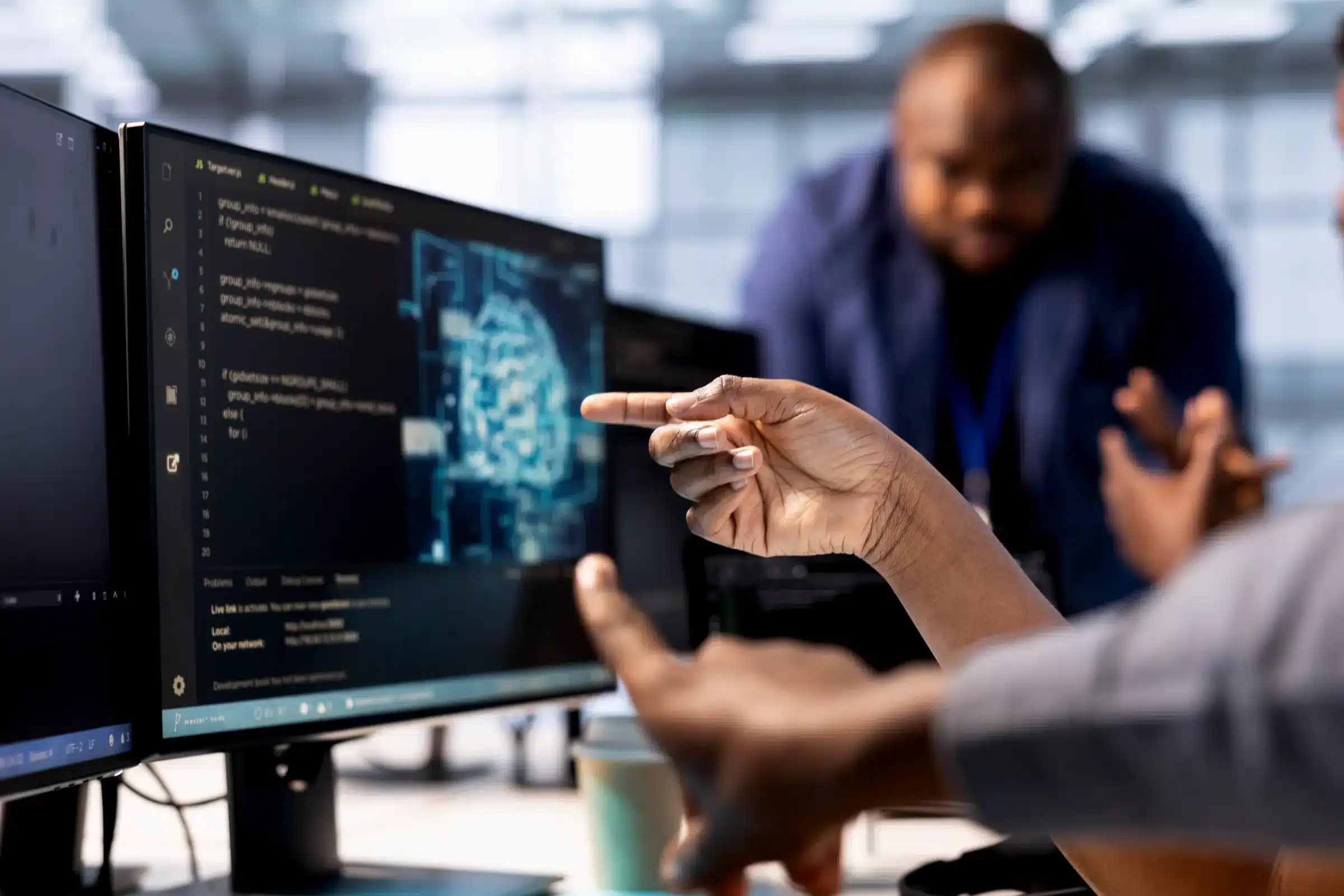 Profissional apontando para código de inteligência artificial em tela de computador, evidenciando o papel fundamental dos treinadores de IA no avanço da tecnologia.