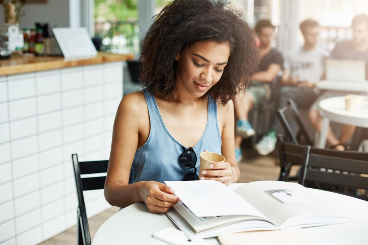 Inscrições concurso UFT 2026 – candidata lendo edital em café com copo na mão