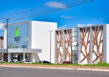 Fachada externa do campus do Instituto Federal do Acre com arquitetura moderna em tons brancos e detalhes em madeira sob céu azul