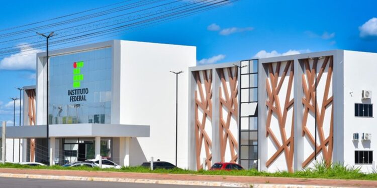 Fachada externa do campus do Instituto Federal do Acre com arquitetura moderna em tons brancos e detalhes em madeira sob céu azul