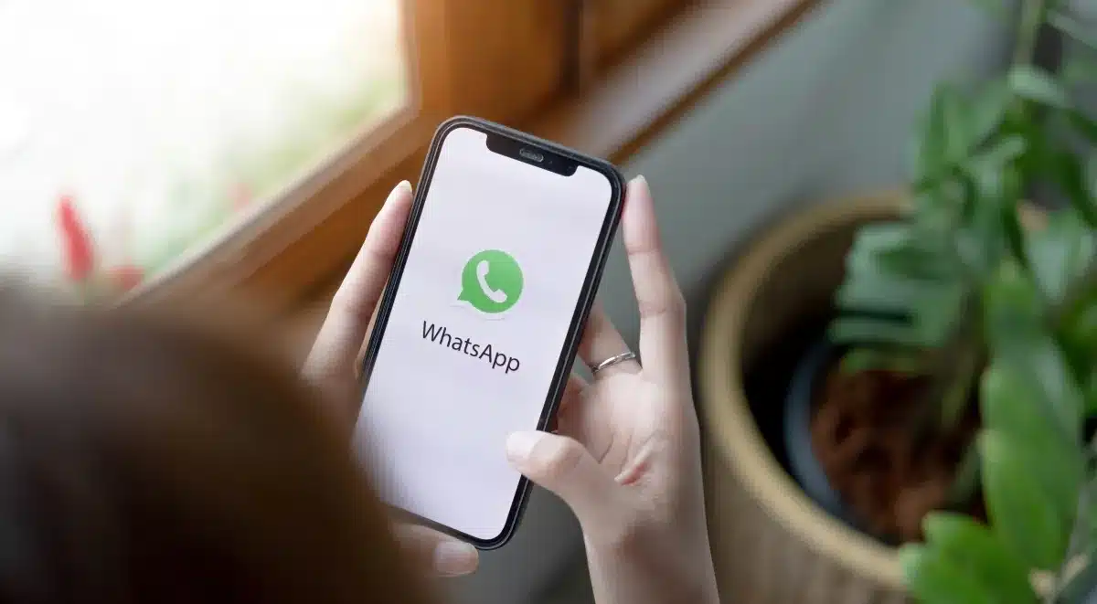 Pessoa usando o WhatsApp no celular representando o recurso que permite bloquear mensagens comerciais de empresas