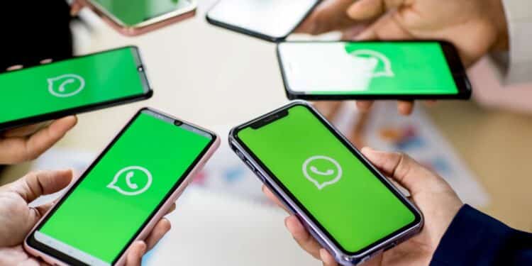 Várias pessoas segurando smartphones com o logo do WhatsApp na tela, representando a possibilidade de usar a mesma conta em múltiplos dispositivos.