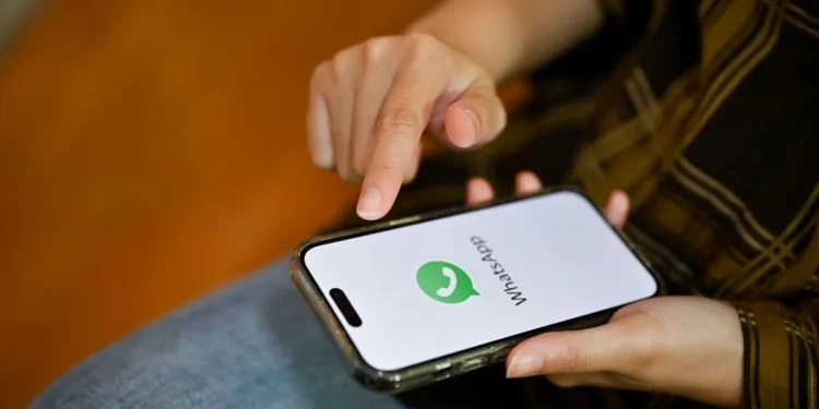 Pessoa utilizando smartphone com WhatsApp aberto representando o novo visual da tela inicial com acesso rápido ao status