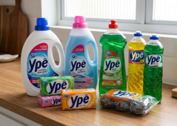 Produtos Ypê incluindo detergente, amaciante, multiuso, sabão em barra e lã de aço dispostos em bancada de madeira.