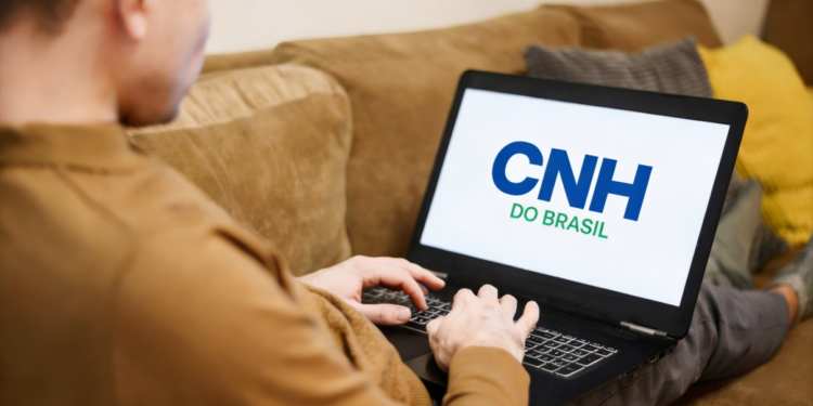 Homem acessa plataforma CNH do Brasil em notebook no sofá.