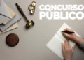 mesa com martelo de juiz e caderno aberto, Nome "CONCURSOS PÚBLICOS" em destaque.