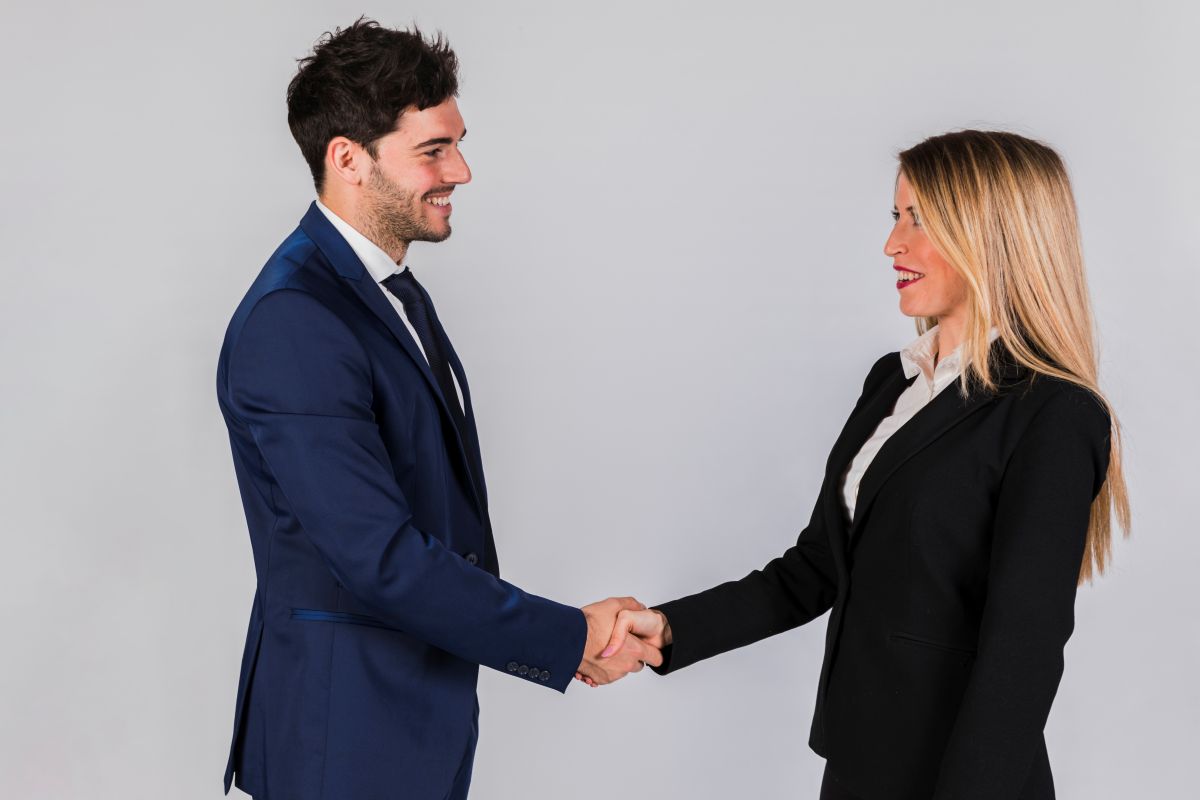 Aperto de mãos entre executivos em ambiente corporativo.