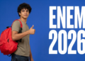 Jovem de cabelos cacheados com mochila vermelha fazendo sinal de positivo ao lado do texto ENEM 2026 em fundo azul.