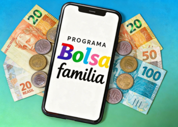 Programa Bolsa Família exibido em smartphone com cédulas de brasileiras no fundo.