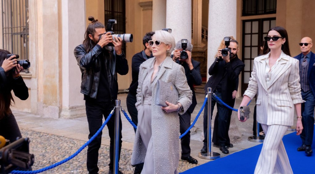Miranda Priestly e Andy Sachs chegam a evento de moda cercadas por fotógrafos em cena de O Diabo Veste Prada 2.