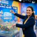 Apresentadora segura bola 33 ao lado de globo com bolas coloridas no sorteio da Loteria dos Sonhos