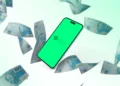 Smartphone com logo do Pix cercado por notas de 100 reais.