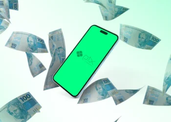 Smartphone com logo do Pix cercado por notas de 100 reais.