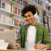 Estudante usando notebook e fones de ouvido enquanto aprende idiomas em uma biblioteca.