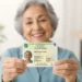 Mulher idosa segura a Nova Carteira de Identidade, representando a ação especial do SAC para emissão do documento.