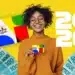 Mulher negra sorridente com blusa laranja segura cartão do Bolsa Família rodeada por notas de R$100