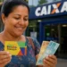 Beneficiária do Bolsa Família segurando cartão do programa e dinheiro em frente à Caixa, representando os pagamentos do programa nesta semana, de 22 a 25 de maio.