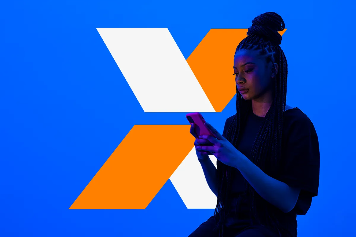 Jovem mulher com tranças consultando o celular sobre fundo azul com letra X em laranja e branco