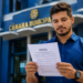 Homem de camisa azul segura documento com título "Edital" em frente ao prédio azul da Câmara Municipal.