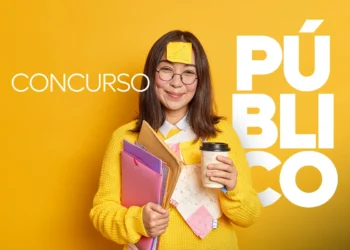 Jovem de suéter amarelo com óculos e post-it na testa segura pastas, cadernos e copo de café.