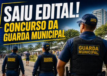 Guardas municipais uniformizados com coletes e bonés patrulhando área urbana com prédios ao fundo