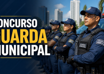 Quatro guardas municipais enfileirados com uniforme azul-marinho, boné e colete tático, viatura ao fundo