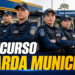 Oito guardas municipais fardados de azul-marinho com coletes e bonés, braços cruzados, em frente à base operacional