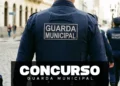 Guardas Municipais de uniforme azul marinho patrulham rua de paralelepípedos em centro histórico brasileiro