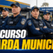 Grupo de 8 guardas municipais uniformizados com coletes e bonés azuis em frente à Base Operacional