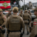 Policiais militares de Santa Catarina com coletes táticos cor cáqui e bonés em formação ao ar livre.