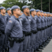 Soldados da Polícia Militar de SP enfileirados com uniformes azuis e boinas durante cerimônia de formatura.