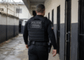 Policial penal do Maranhão caminha por corredor de unidade prisional durante o serviço.