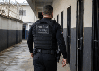 Policial penal do Maranhão caminha por corredor de unidade prisional durante o serviço.