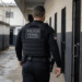 Policial penal do Maranhão caminha por corredor de unidade prisional durante o serviço.