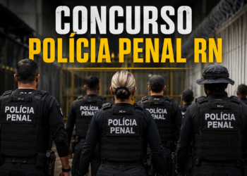Agentes da Polícia Penal de costas com coletes táticos pretos diante de portão amarelo de unidade prisional.