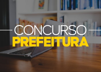 Notebook aberto sobre mesa de madeira com estante de livros ao fundo e texto "Concurso Prefeitura" em amarelo e branco.