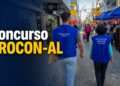 Dois fiscais do PROCON Alagoas com coletes azuis caminham em rua comercial movimentada durante operação de fiscalização