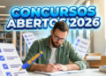 Homem barbudo de óculos e camisa verde escrevendo em caderno, com ícones de checklists e texto "Concursos Abertos 2026"