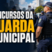 Agentes da Guarda Municipal enfileirados usando uniforme azul marinho, coletes táticos e bonés com inscrição GUARDA MUNICIPAL