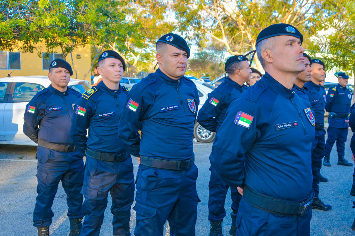 Guardas municipais com uniforme azul-marinho, boinas pretas e distintivos em formação durante evento oficial ao ar livre