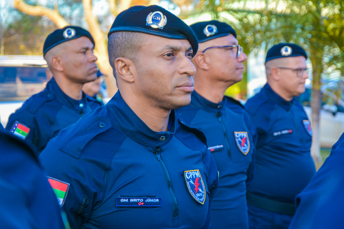 Quatro guardas municipais em uniforme azul-marinho com boinas e brasões CPPM durante cerimônia ao ar livre