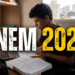 Jovem de cabelos cacheados estuda em mesa com livros, cadernos, notebook e texto "ENEM 2026" sobreposto.
