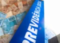Cédulas de real e fachada do prédio da Previdência Social, representando o pagamento do benefício mensal e da primeira parcela do 13º salário antecipado pelo INSS