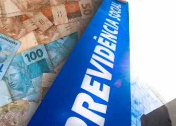 Cédulas de real e fachada do prédio da Previdência Social, representando o pagamento do benefício mensal e da primeira parcela do 13º salário antecipado pelo INSS