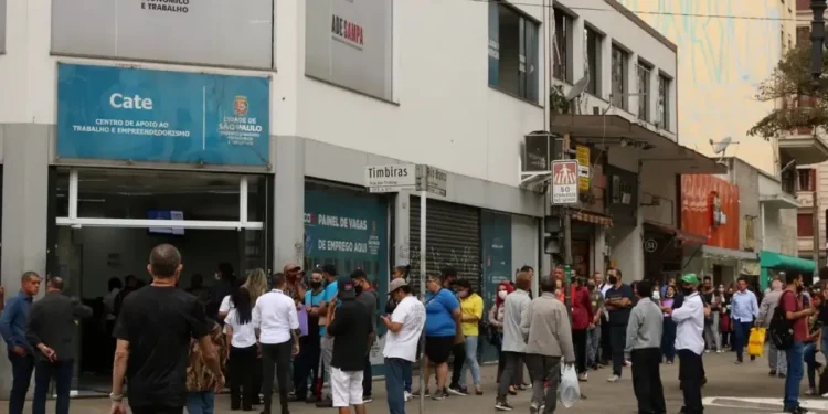Fila de trabalhadores nas ruas representando o período de queda do desemprego no primeiro trimestre