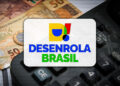 Logotipo colorido do Desenrola Brasil sobre cédulas de cinquenta reais e teclas de calculadora